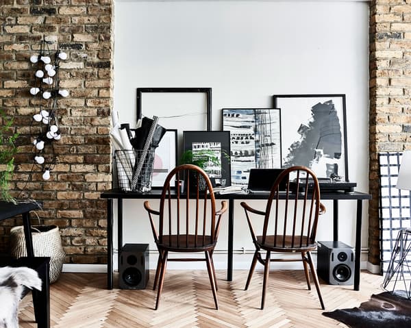 A desk for two people with monochrome artwork.
