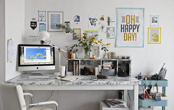 A desk with posters and pictures on the wall 