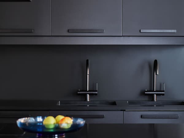 A detail view of a black kitchen with black KUNGSBACKA kitchen fronts made from recycled PET bottles.