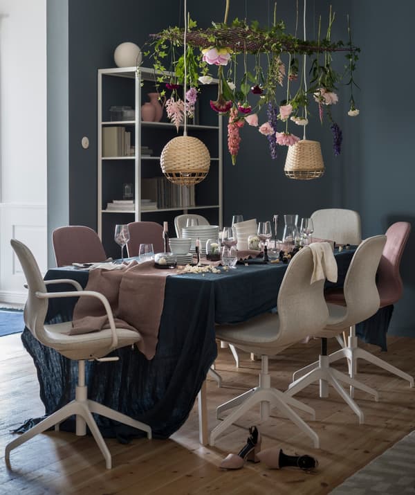 A dining room decorated for a dinner party, using IKEA LÅNGFJÄLL swivel chairs as seating for extra guests.