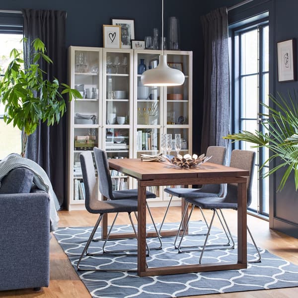 A dining room with four upholstered VOLFGANG chairs in grey with chrome legs and MÖRBYLÅNGA oak veneer table.