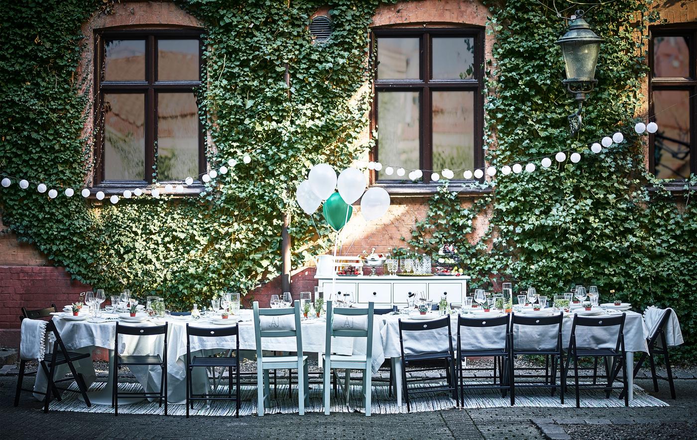 A dining table for a wedding is set up in a courtyard.