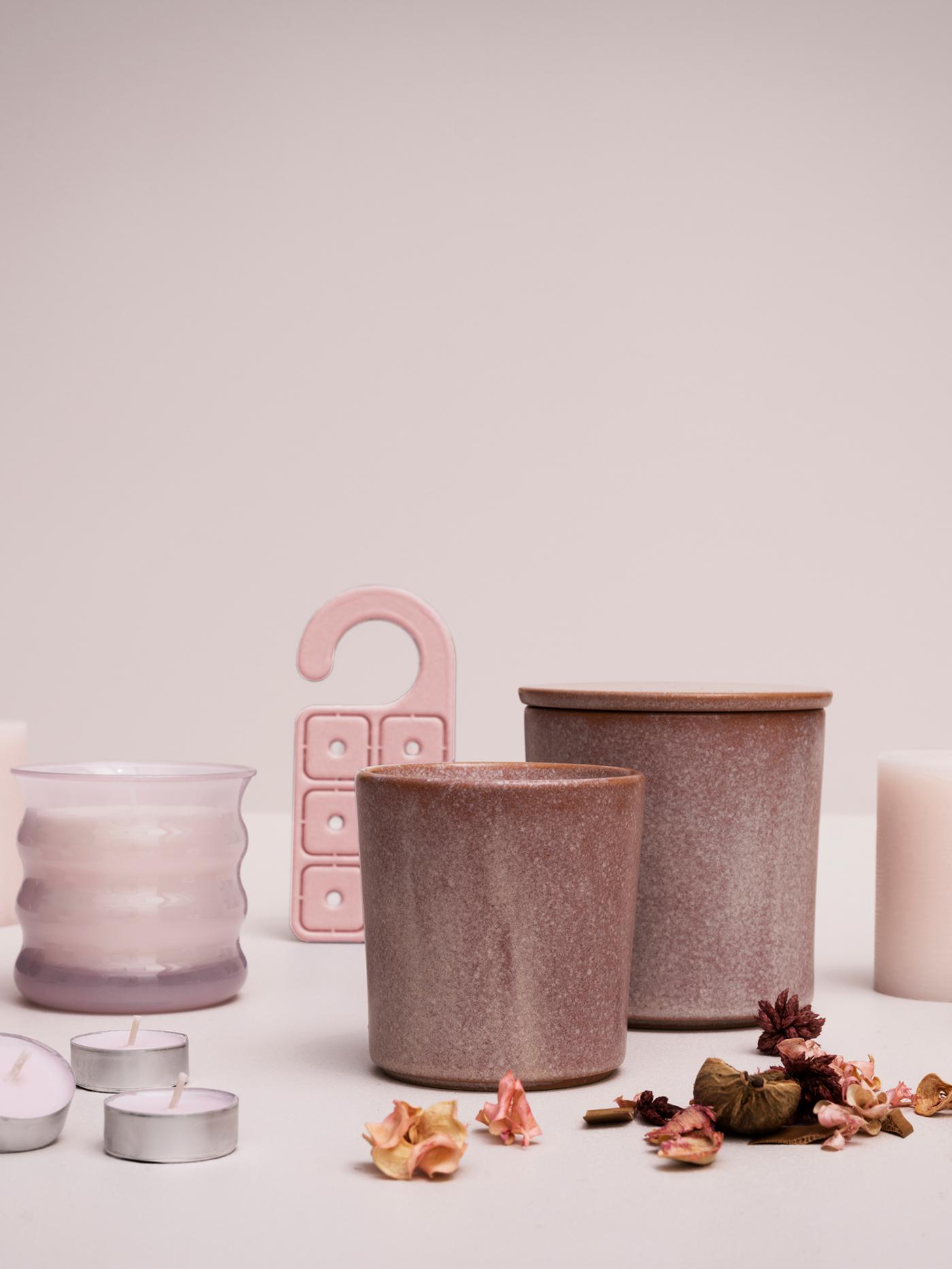 A display of LUGNARE jasmine scented candles, potpourri and a scented hanger against a light pink background.