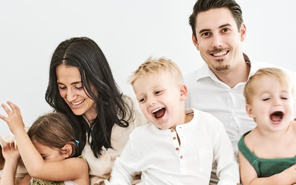 A family of five laughing together.