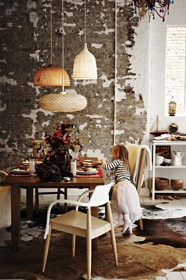 A festive table setting with a large fluffy rug under the warm glow of woven lights. 
