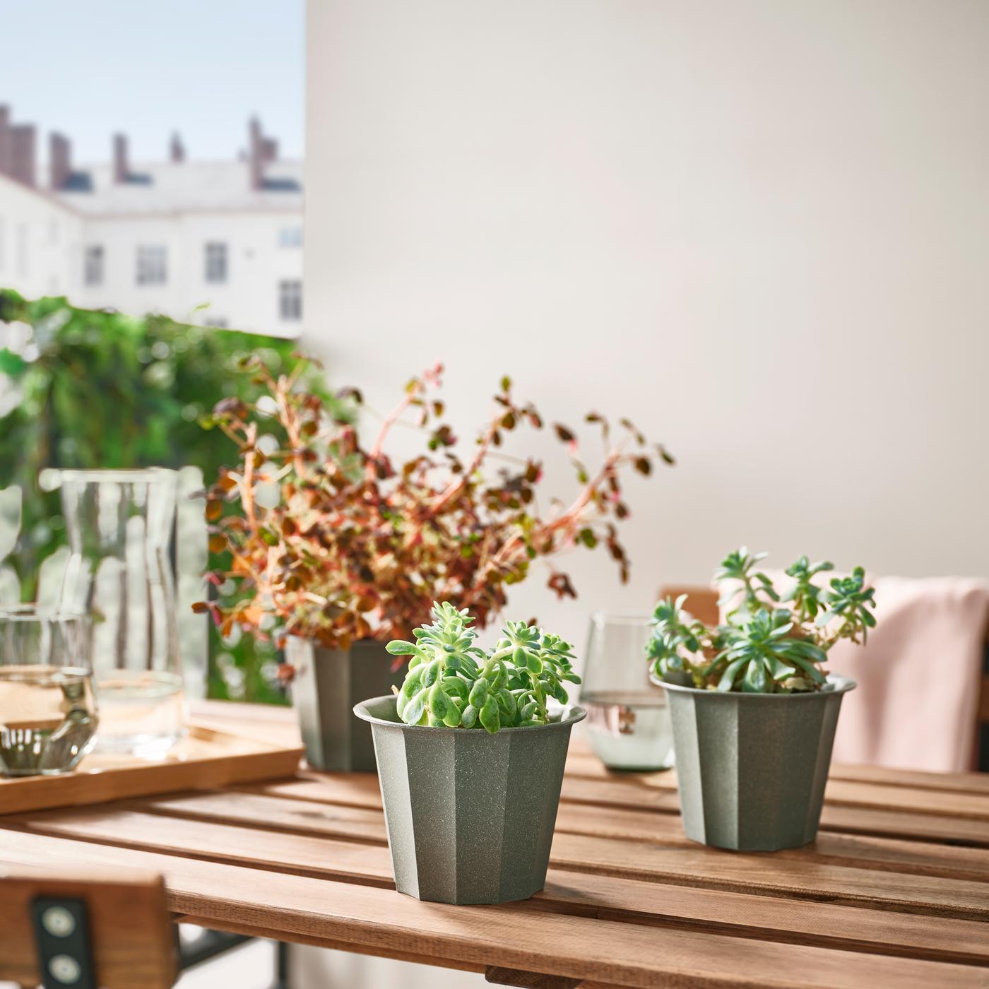A few BUSKVERK pots on an outdoor table in the balcony