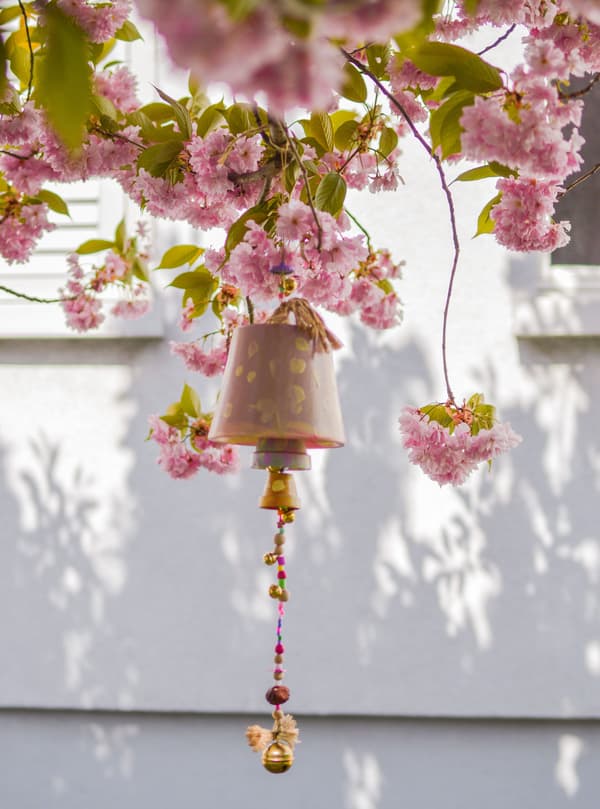 A flowerpot wind chime hanging from a tree