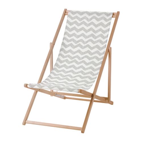 A foldable beach chair in wood with a gray and white patterned fabric seat.