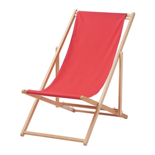 A foldable beach chair in wood with a red fabric seat.