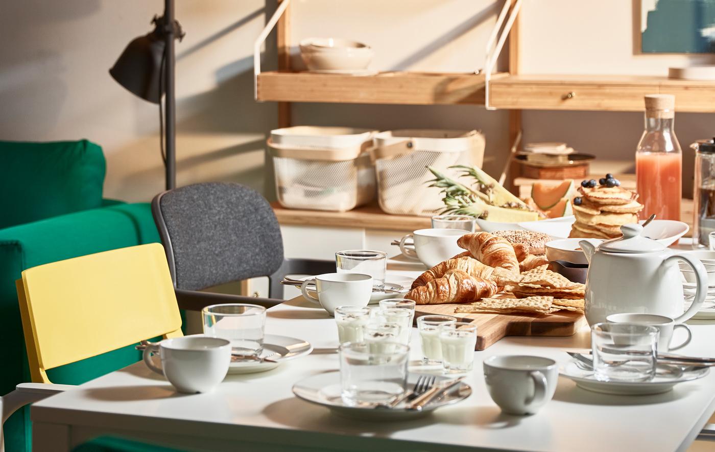 A fresh table setting with a modern mix of dinnerware, cutlery and beautiful wine glasses.