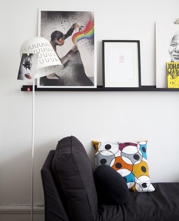 A gallery wall above a chaise longue.