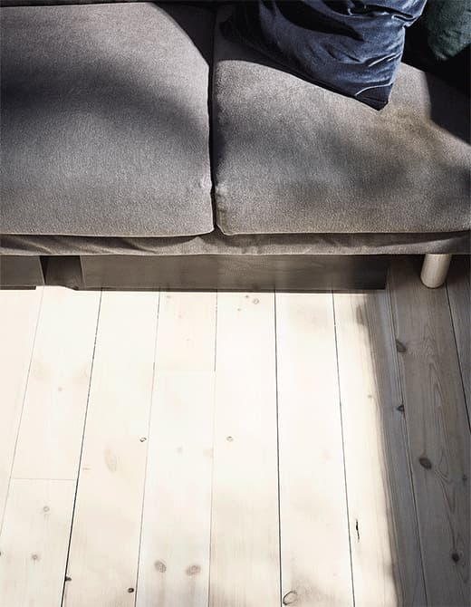 A GIF of a VARDÖ storage box on wheels sliding out from under the sofa to reveal organised home exercise equipment.