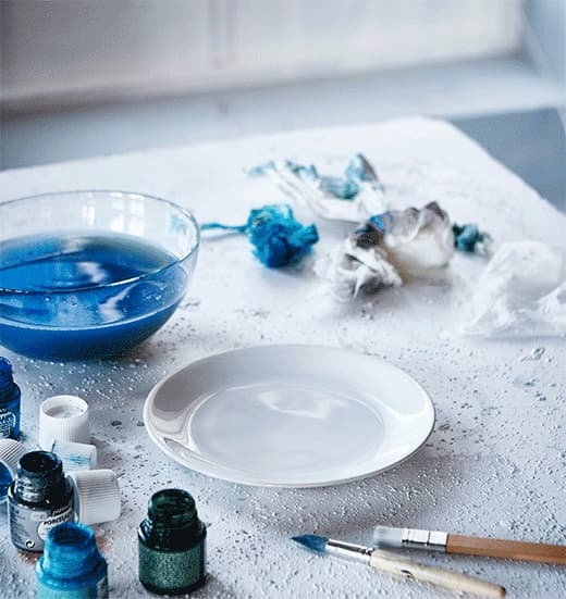 A GIF of a white IKEA FÄRGRIK plate being splatter-painted.