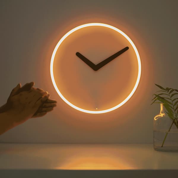 A gif shows a wall clock lit up and hands clapping.