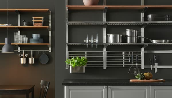 A gray kitchen wall with many shelves in stainless steel and wood, holding pots, pans, knives, and bowls