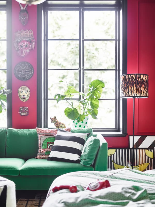 A green sofa and masks on the wall help give this dream bedroom it’s own distinctive look.