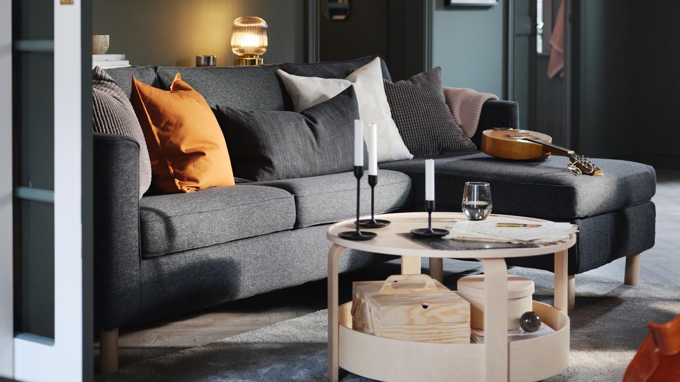 A green-walled living room with a dark-grey PÄRUP three-seat sofa with chaise longue, and a BORGEBY birch coffee table.