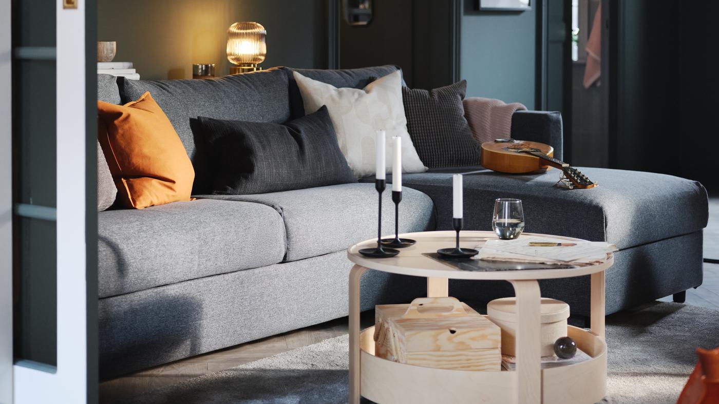 A green-walled living room with a VIMLE three-seat sofa with chaise longue in medium grey, and a BORGEBY birch coffee table.