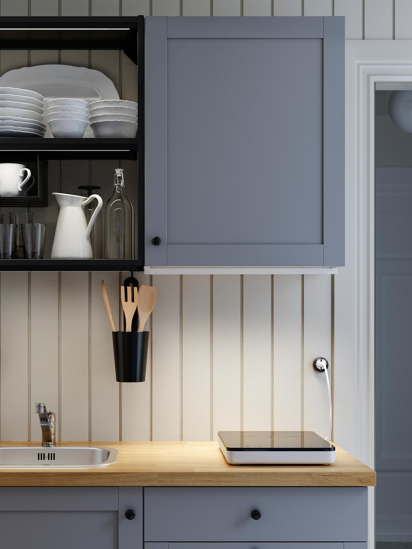 A grey/anthracite/wooden ENHET kitchen, a portable induction hob and LED lighting strips that illuminate the worktop.
