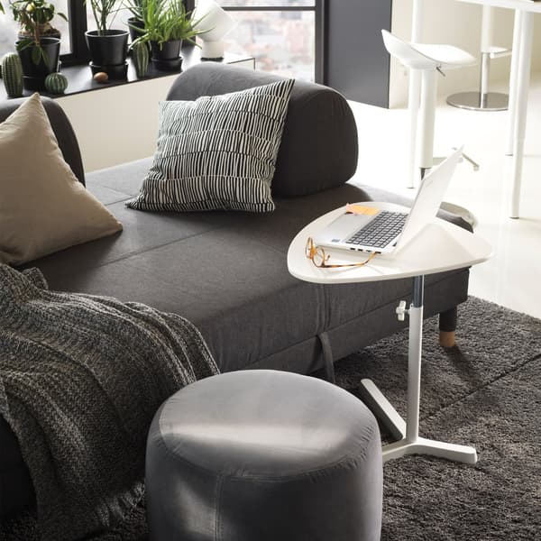 A grey IKEA FLOTTEBO sofa bed with movable cushions with a laptop table close at hand.