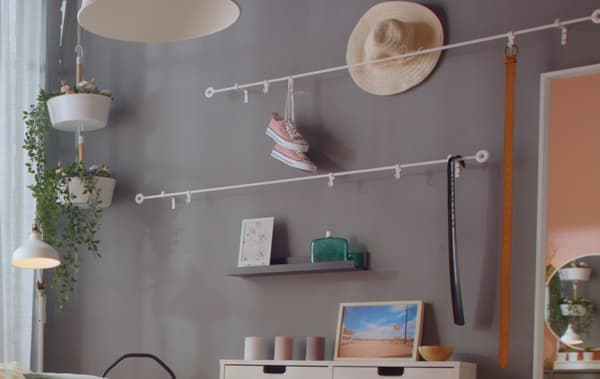 A grey wall with curtain rods with shoes on