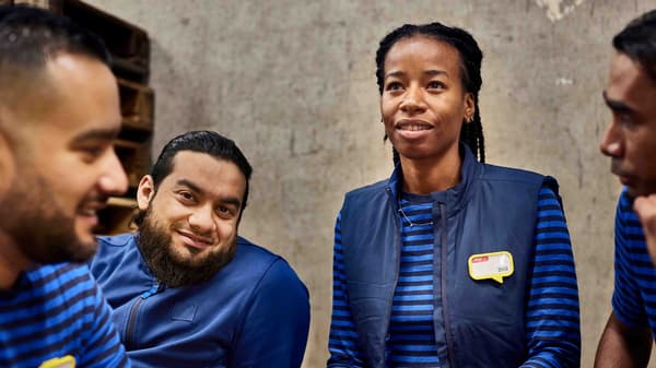 A group of IKEA co-workers wearing blue IKEA uniforms.