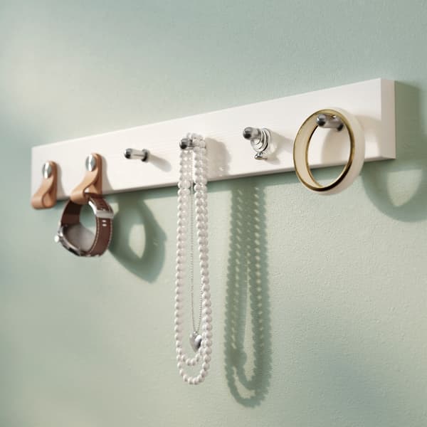 A hall rack decorated with IKEA ÖSTERNÄS leather handles and holding a watch, beads and some tape.