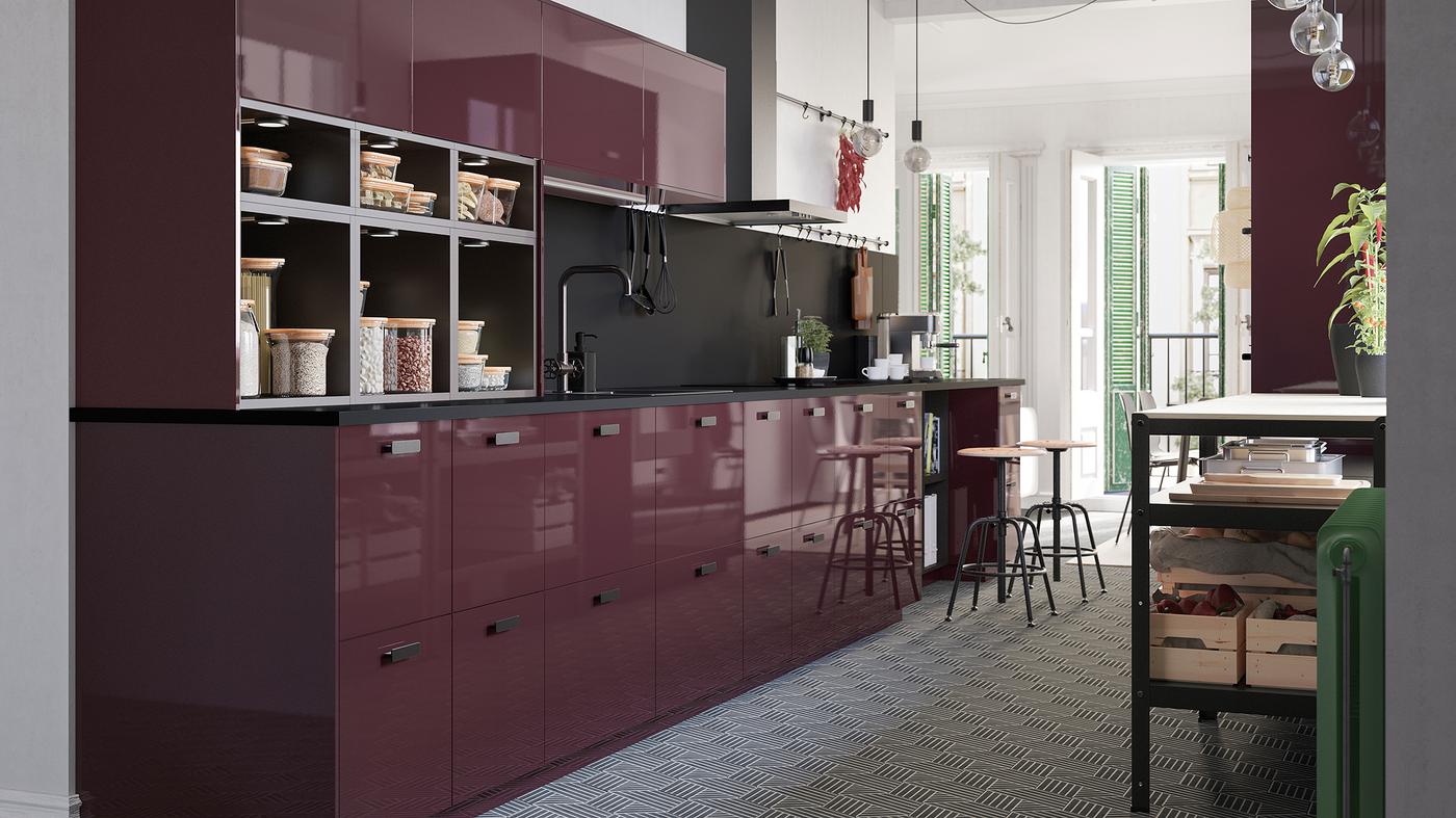 A high-gloss kitchen in burgundy, a hexagon-patterned floor and naked light bulbs on cords that hang from the ceiling.