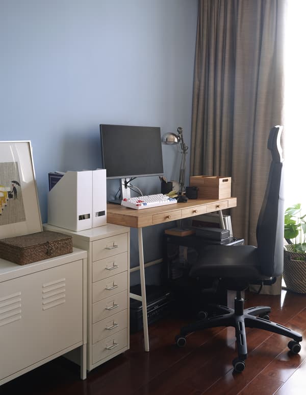 A home office corner against a blue wall.
