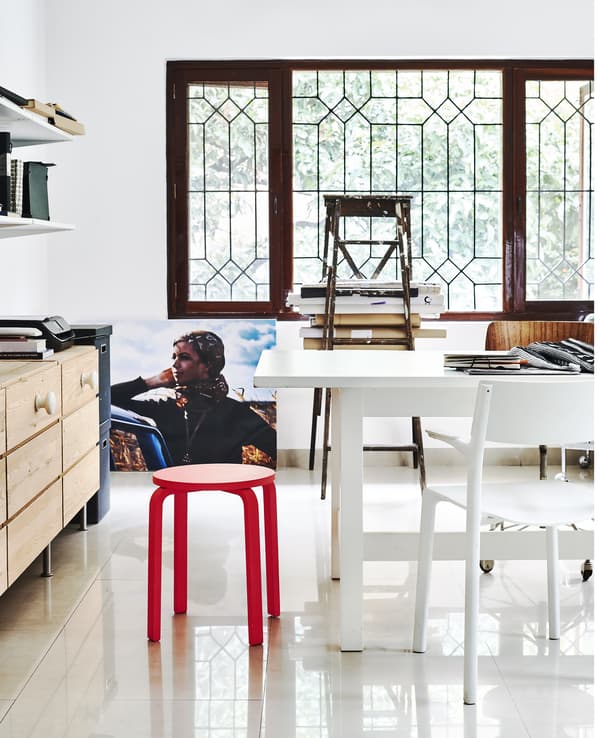 A home office with large white table and storage units.