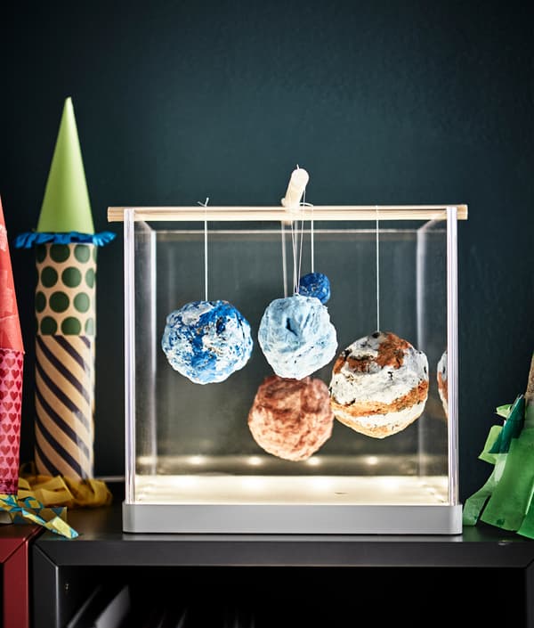 A homemade planetary system is displayed in a light box.