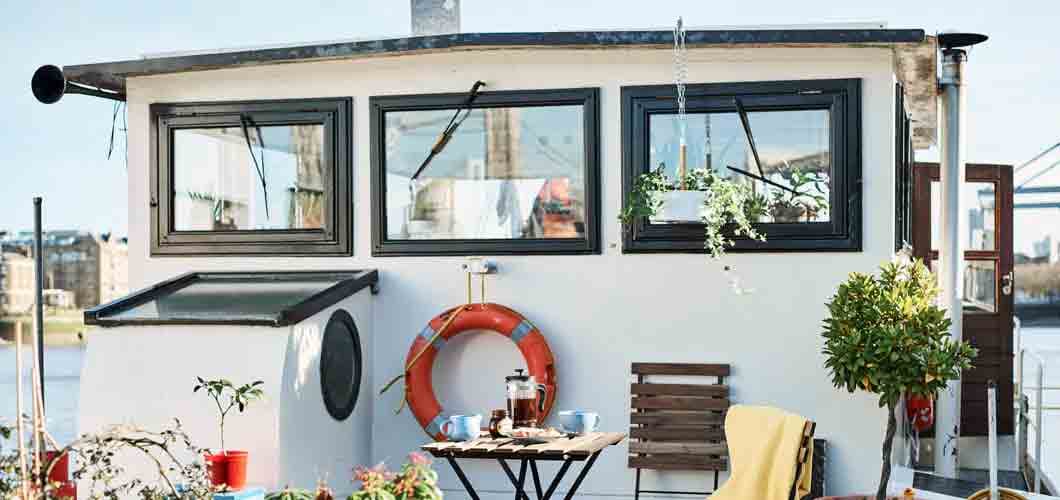 a-houseboat-deck-with-outdoor-table-and-foldable-chairs