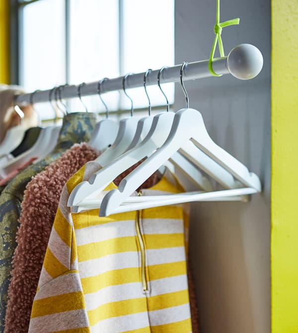 A HUGAD curtain rod attached to the ceiling for hanging up clothes