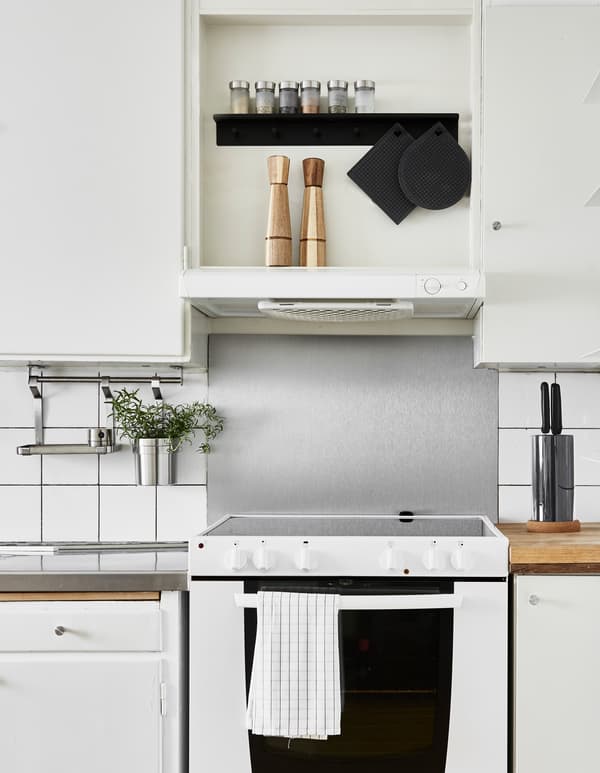 A kitchen is updated using easy, space-saving ideas. By adding a hanging rail for drying the dishes and to store extra utensils for cooking, you free up worktop space.