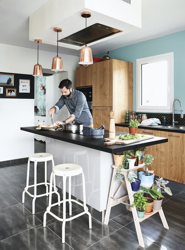 A kitchen island with stools and pendant lamps.