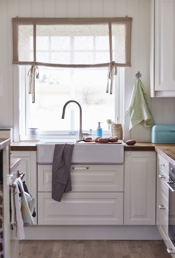A kitchen sink area with a window that allows natural light to flow into the small kitchen space.