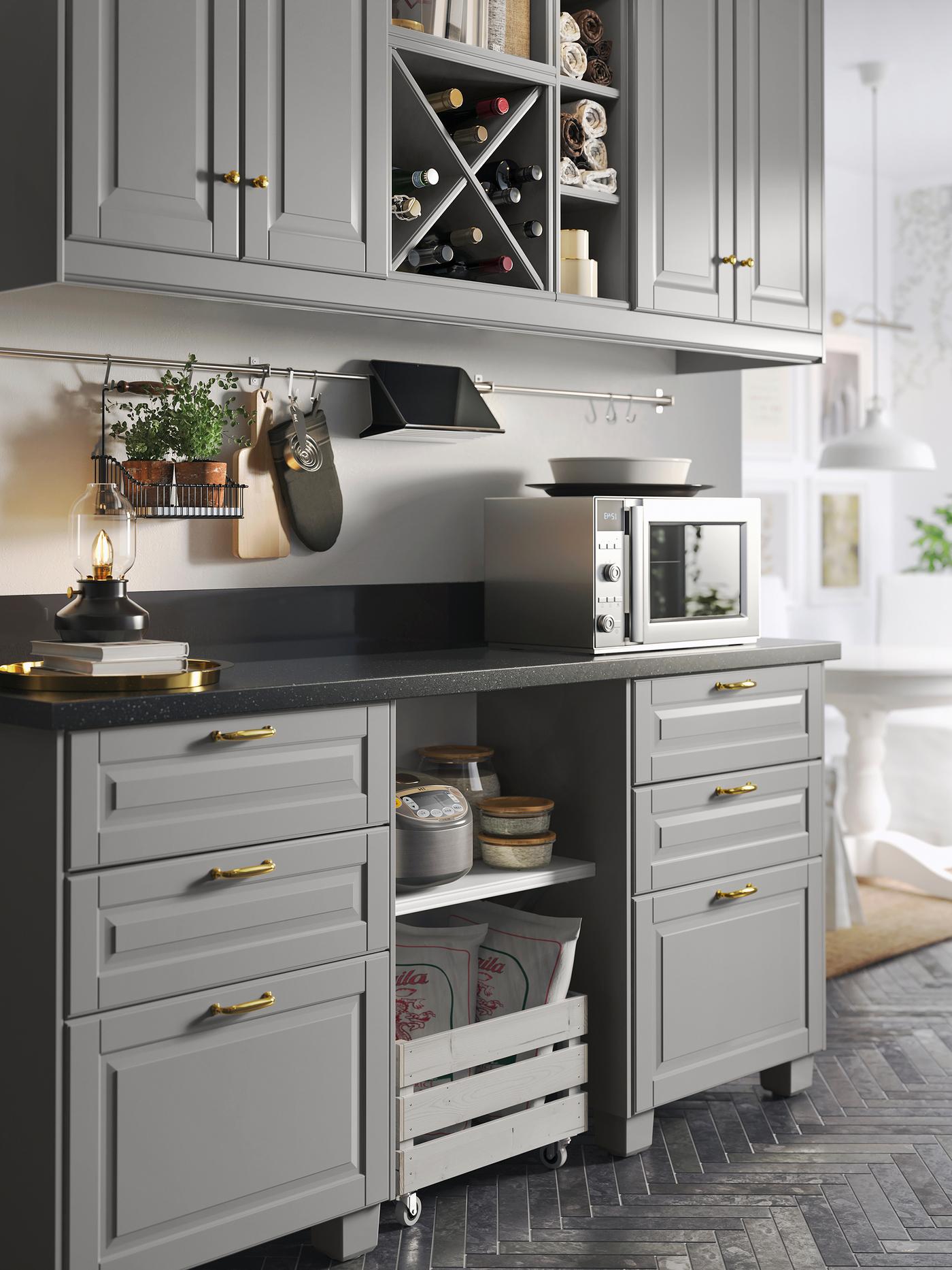 A kitchen with four grey cabinet doors, a black mineral-effect worktop and base cabinets with six grey drawer fronts.