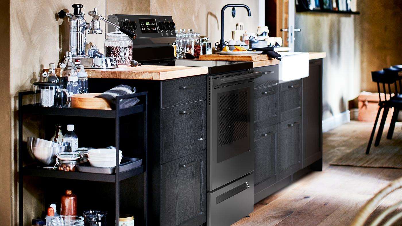 A kitchen with stained black LERHYTTAN cabinet fronts, an oak/veneer worktop and a white sink with visible front.