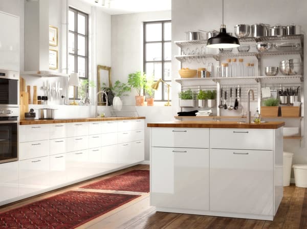 A large brown and white kitchen with an island that combines white RINGHULT doors in high gloss with a SKOGSÅ oak worktop.