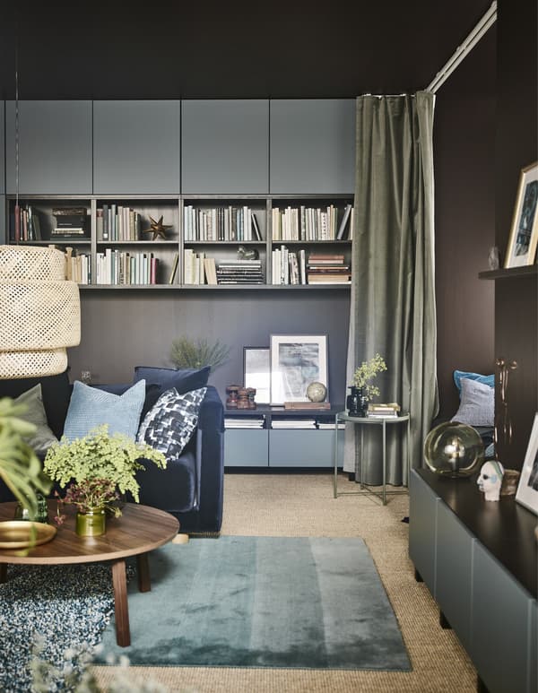 A large modern living room with dark brown walls and turquoise furnishings.