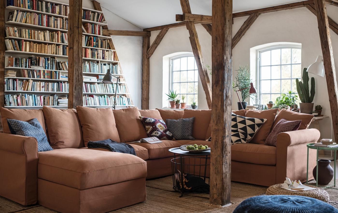 A large U-shaped sofa in a room with exposed beams.