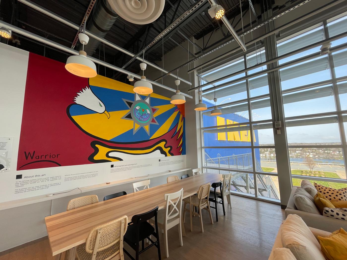 A large wall mural is showcased in a brightly lit building. 