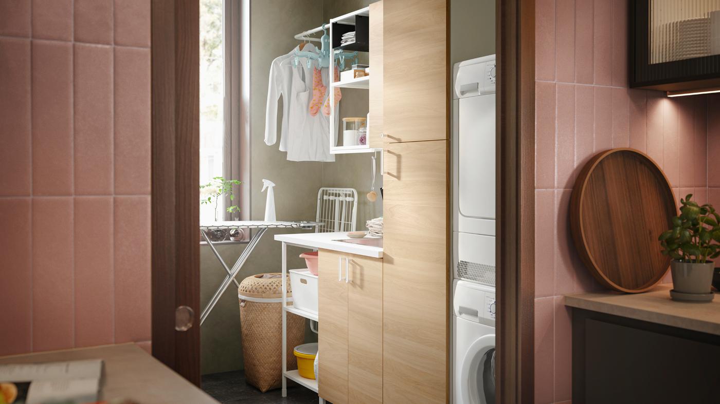 A laundry area with an ENHET laundry solution, washing machine, DÄNKA ironing board and a SALUDING laundry basket.