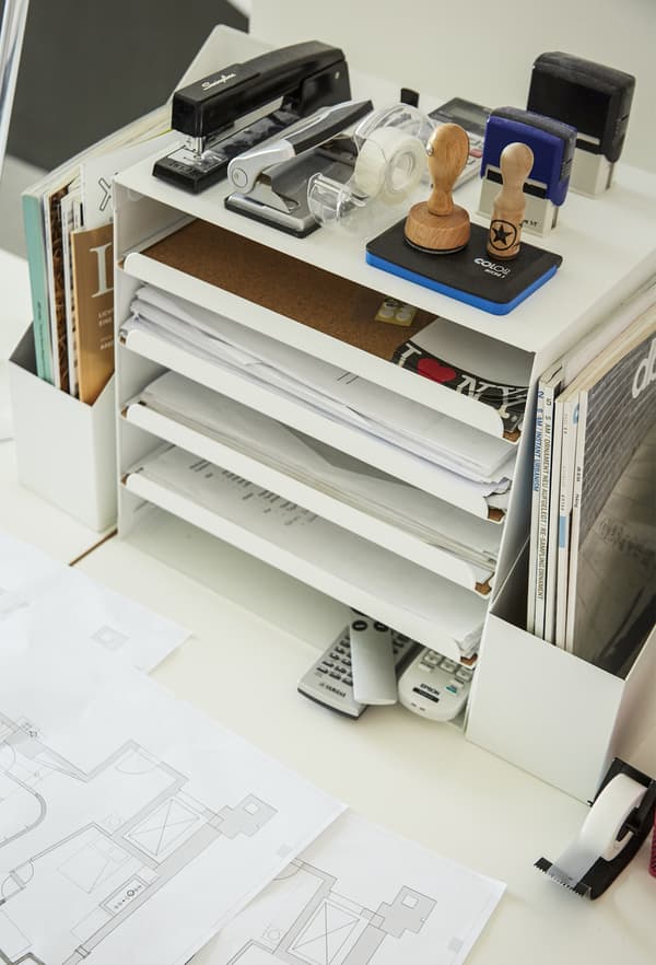 A letter tray and stationery on a desk.