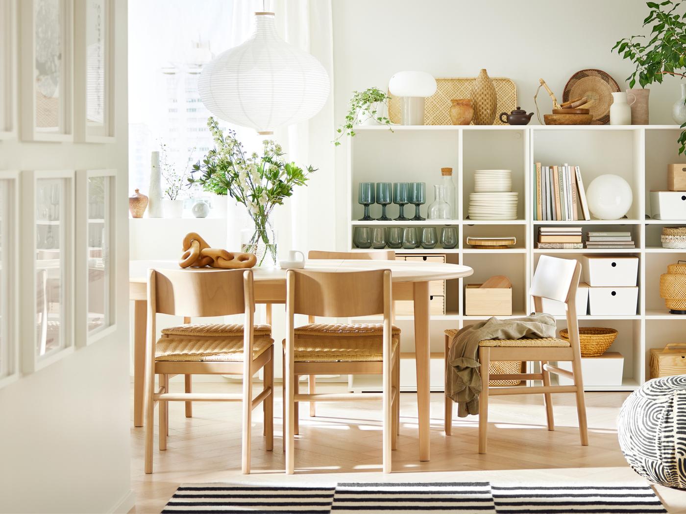 A light beech/veneer SKANSNÄS round extendable table and SKANSNÄS light beech chairs stand in a room with a wooden floor.