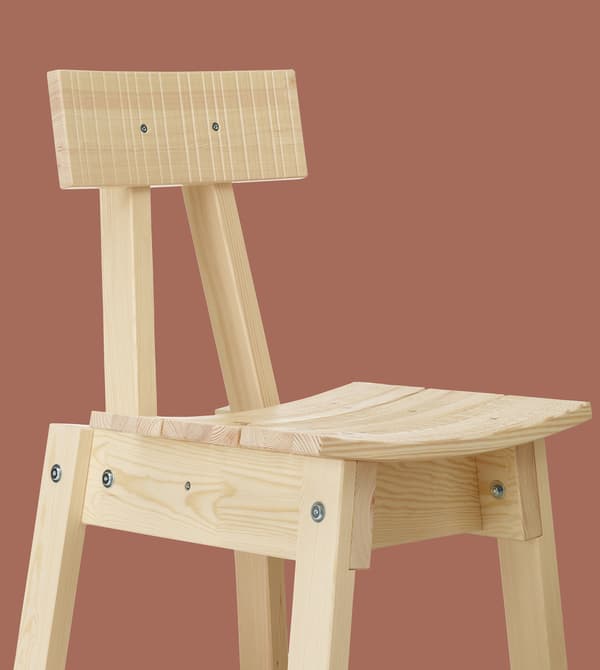 A light wood chair on a terracotta background.