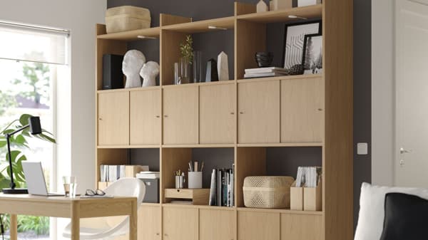 A light wooden look LÅDMAKARE storage system with open and closed surfaces.