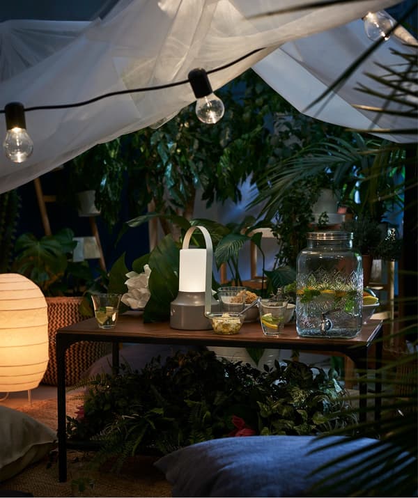 A lighting chain and lanterns in an outdoor dining setting.