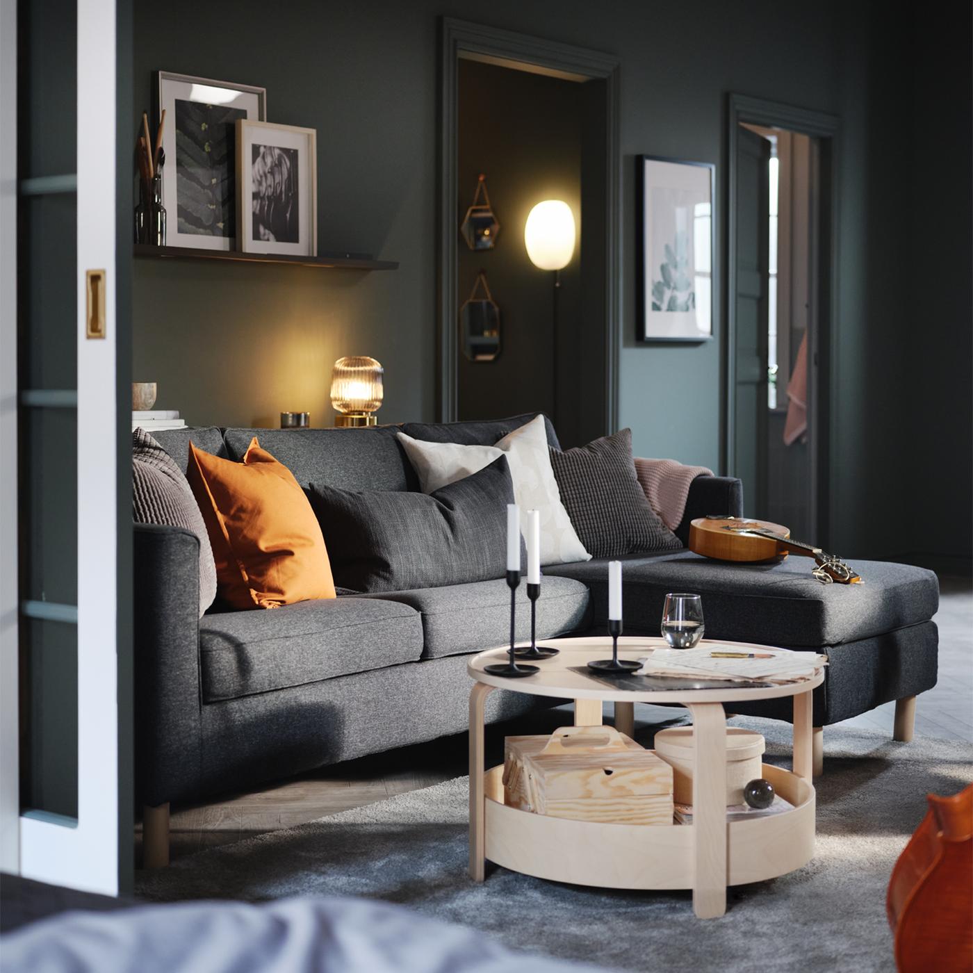 A living area with a birch veneer BORGEBY coffee table in front of a dark grey PÄRUP 3-seat sofa with chaise longue.