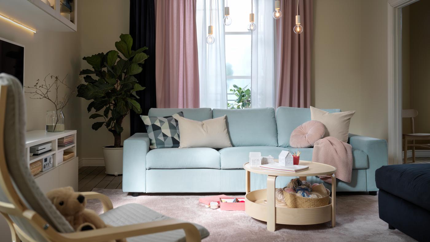 A living room in a pastel color scheme with a light-blue VIMLE sofa, light-pink KALKFLY curtains and a BORGEBY coffee table.